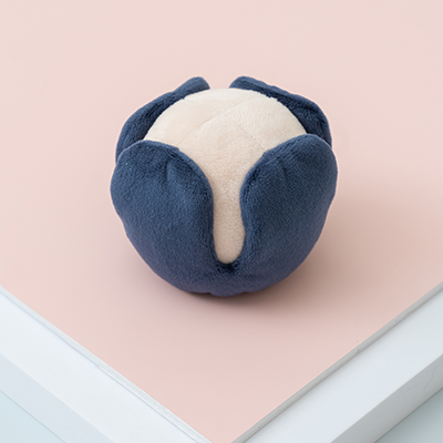 Blue and white plush toy on a pink surface