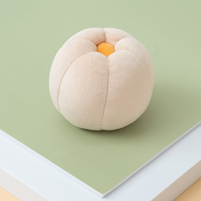 Plush peach toy on a green and beige background