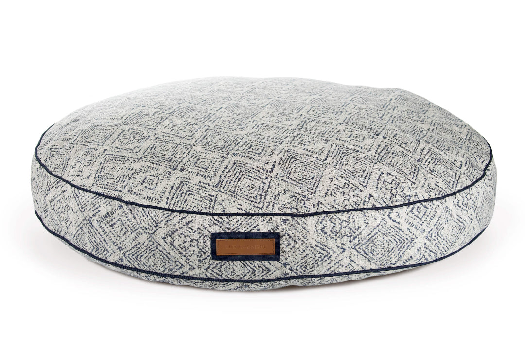 Round gray pet bed with a pattern and brown label on a white background