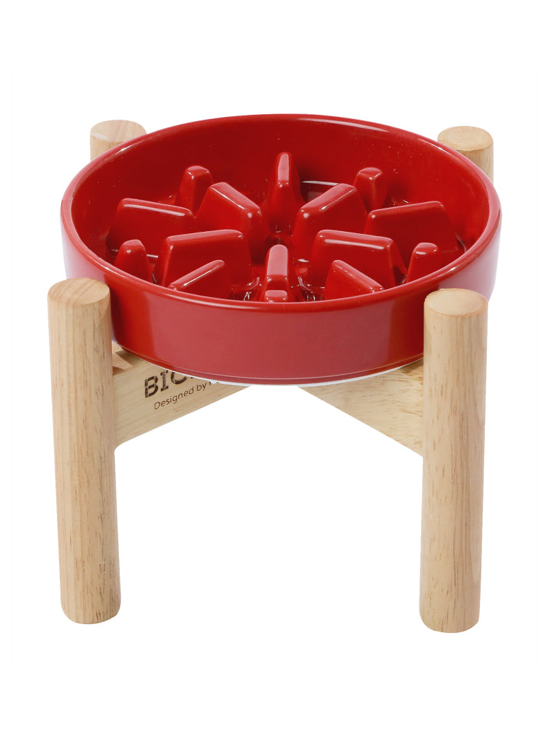 Red pet bowl with wooden stand on a white background