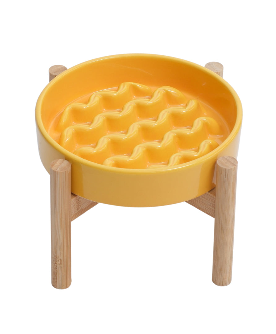 Yellow waffle-patterned bowl on a wooden stand against a white background