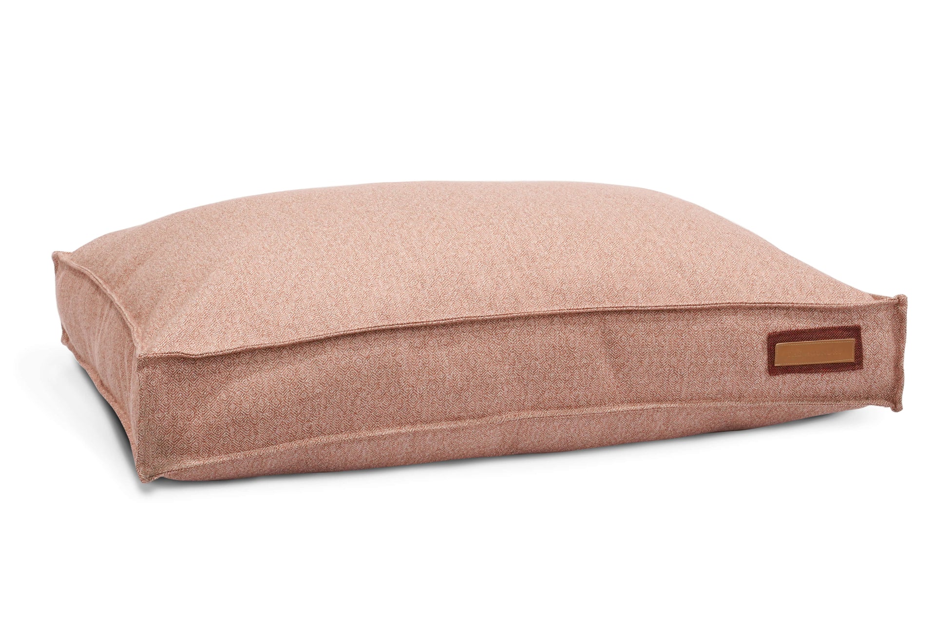 Beige pet bed with a brown label on a white background